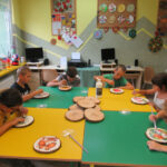 Dzieci ozdabiają plastry z drewna jesionu metodą decoupage.