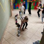 Dzieci ustawiają buty w rząd w zabawie „But za progiem”